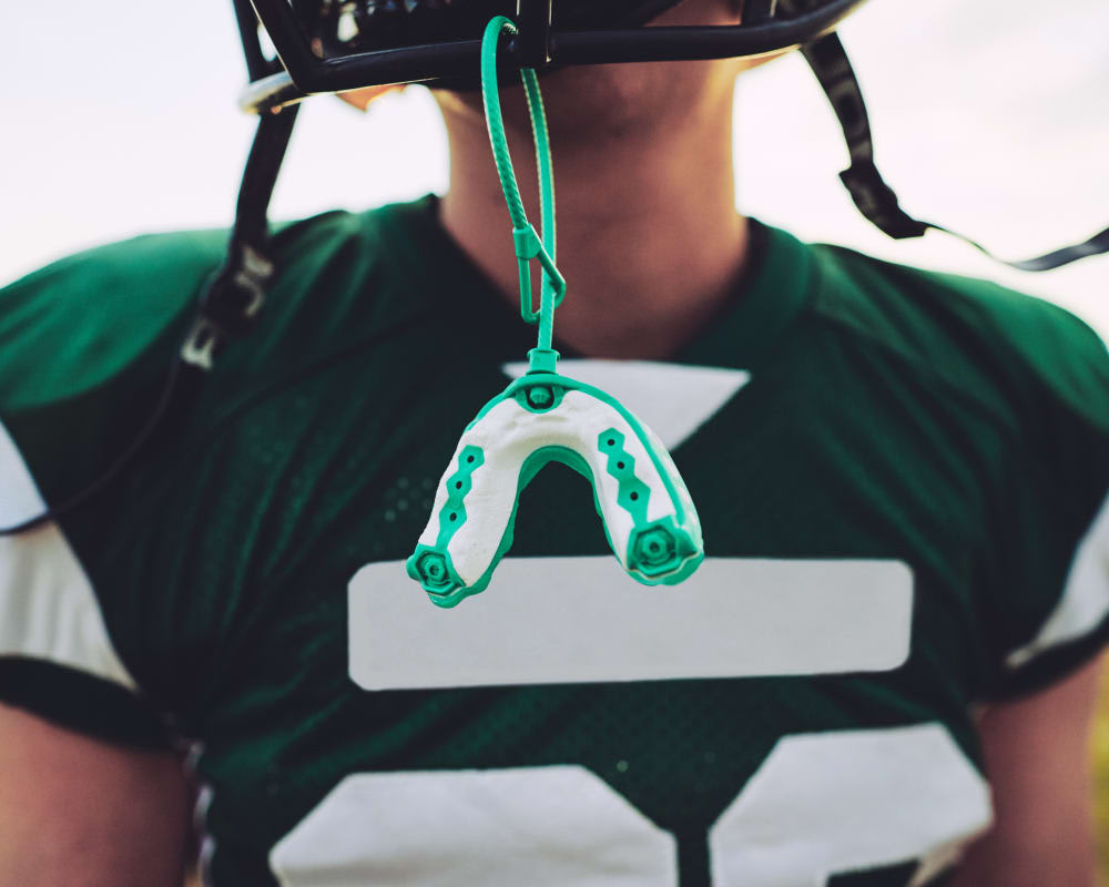 A mouth guard hangs off of a football helmet.